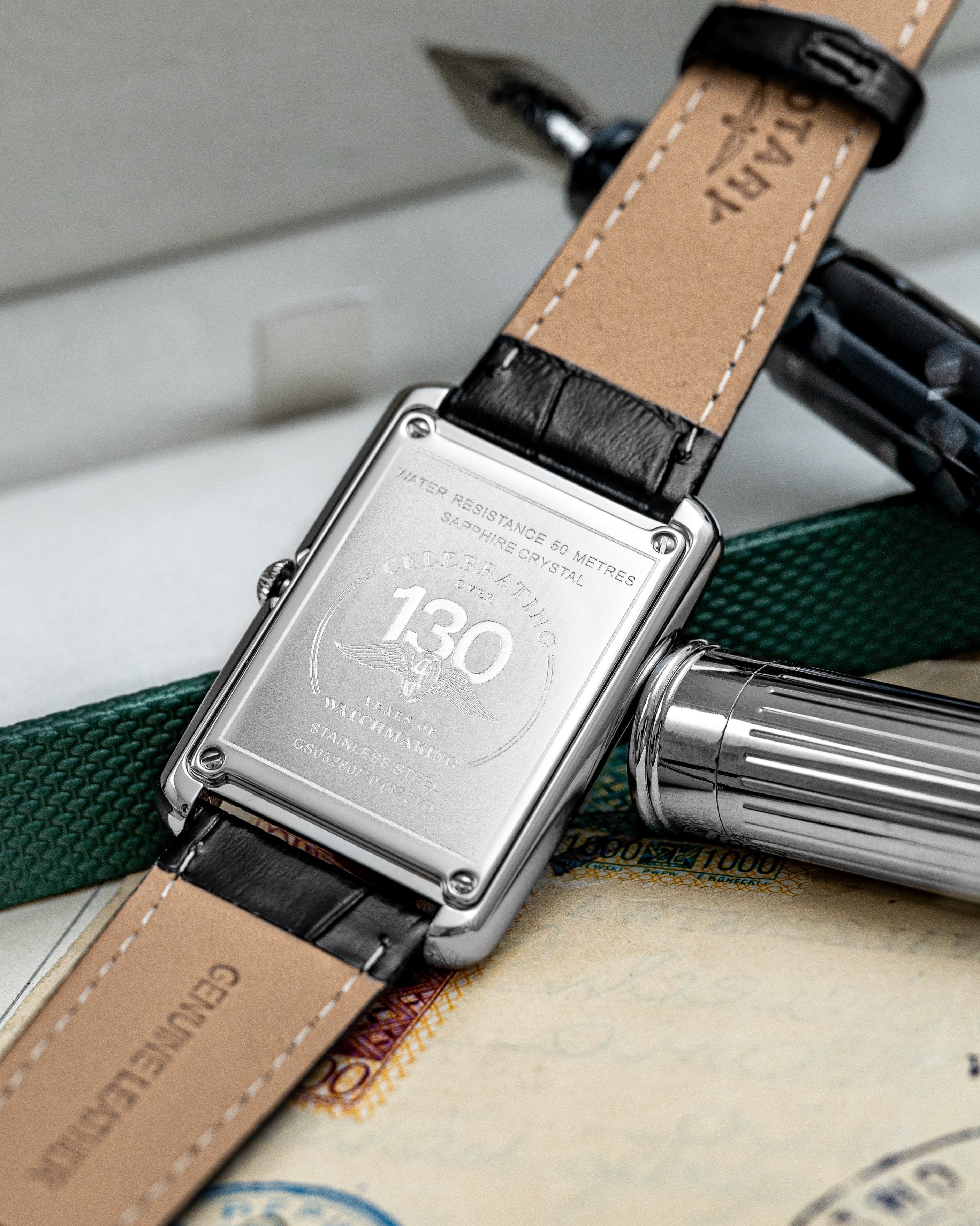 Rotary watch with a leather strap on a textured surface