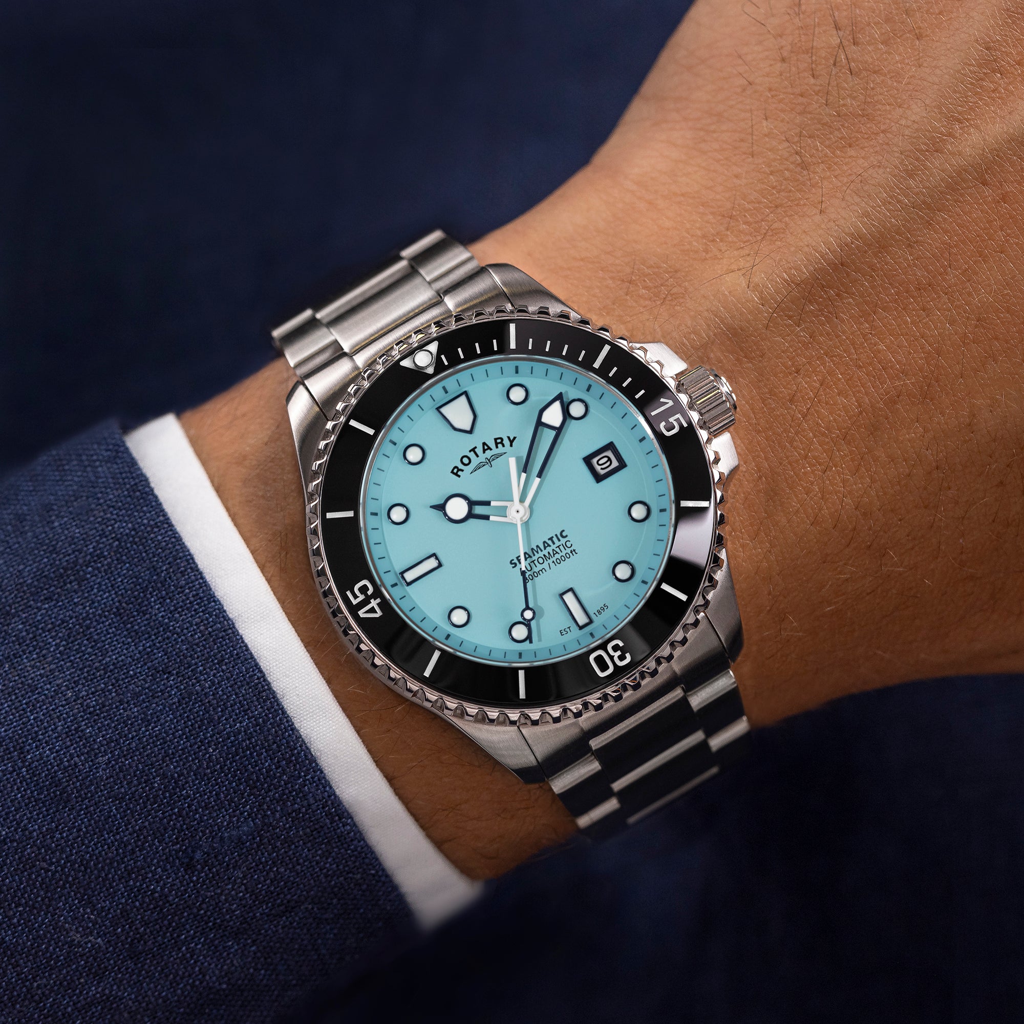 Close-up of a wrist wearing a Rotary Seamatic watch with a blue face and silver metal strap.