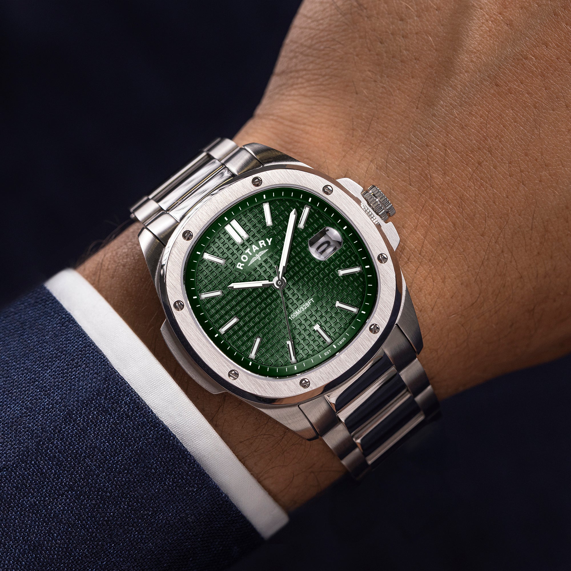 Silver Rotary Apex100 watch with a green face on a wrist, with Rotary logo visible