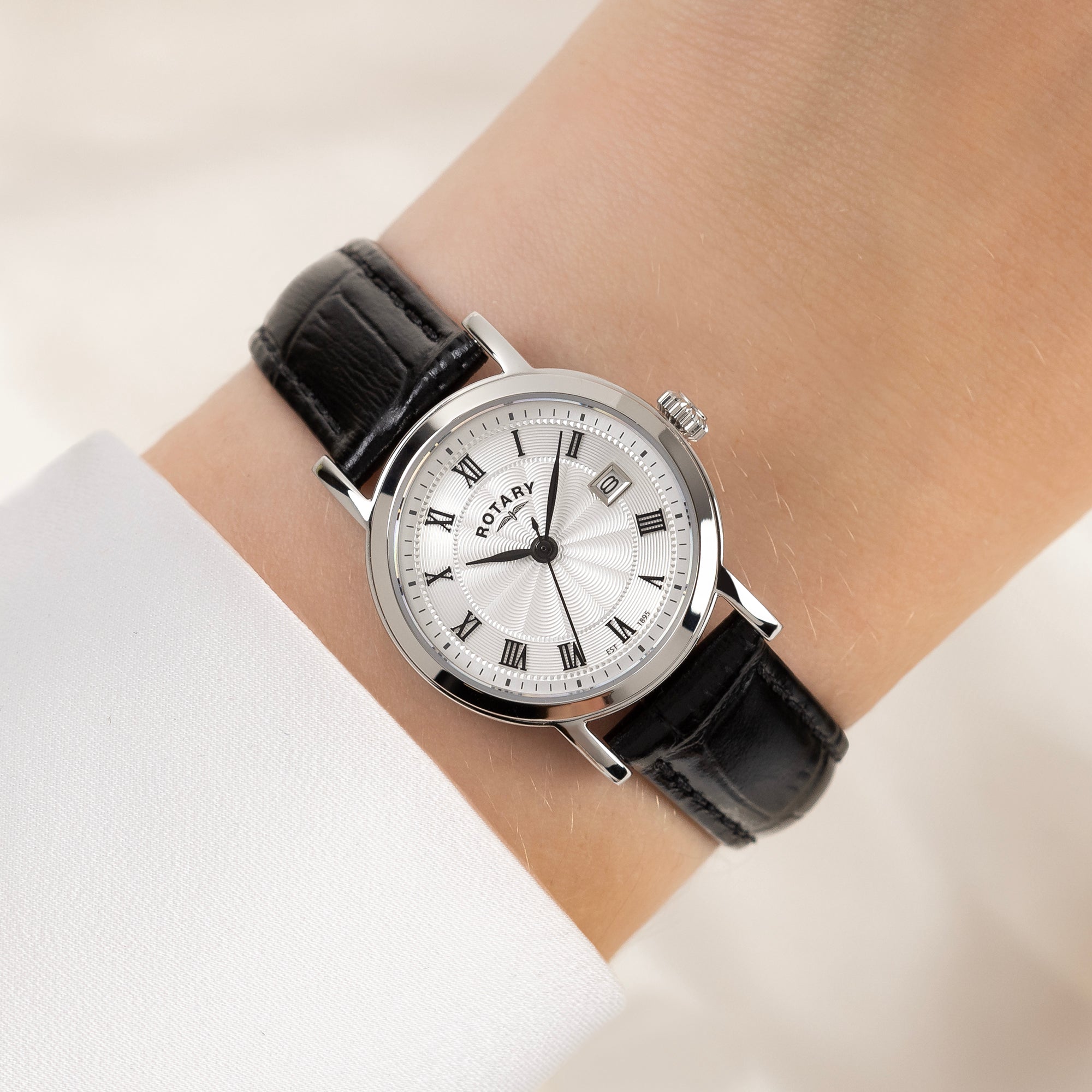 Rotary ladies wristwatch with black strap and white dial on a wrist