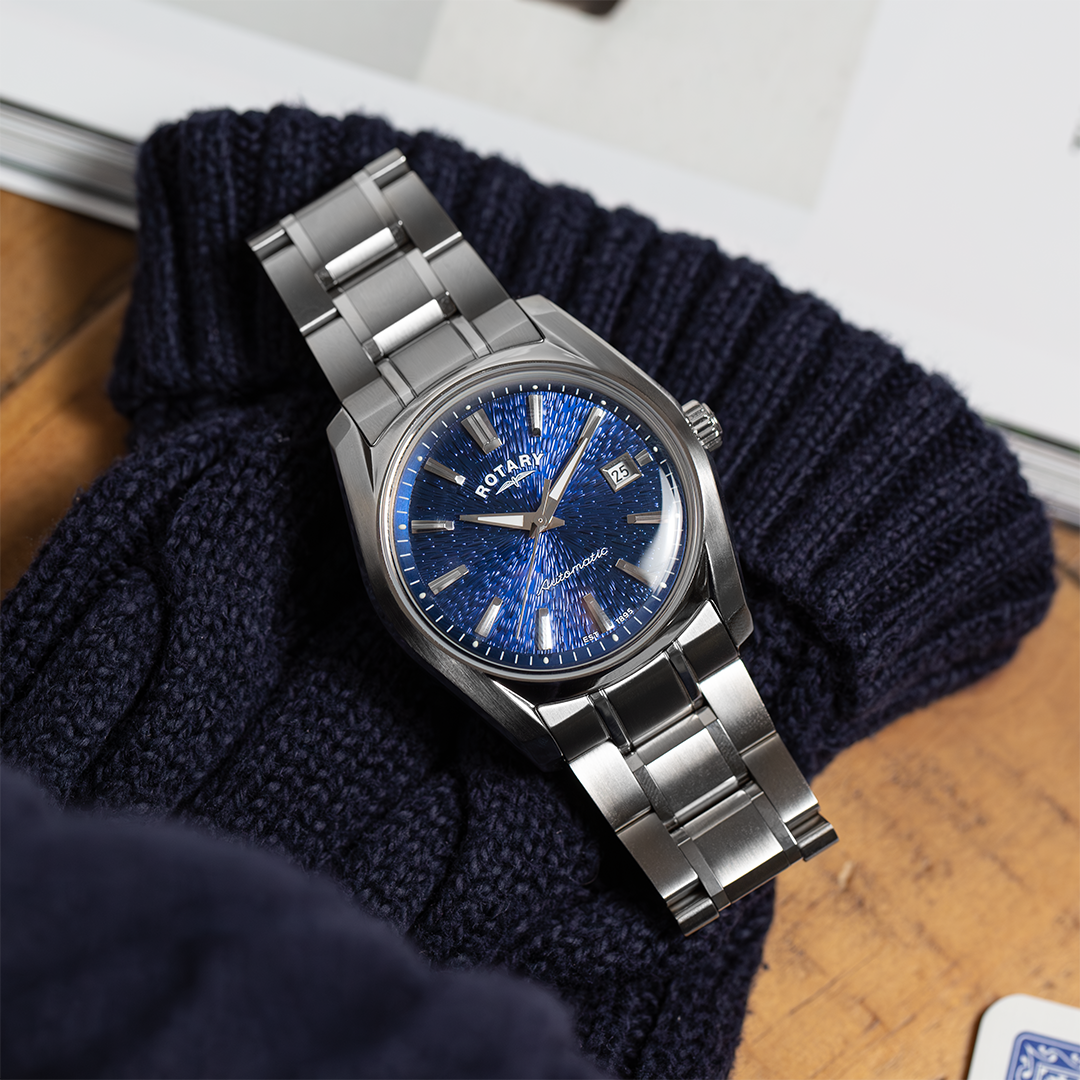 Silver Rotary Lumen watch with blue face on a dark blue knitted fabric