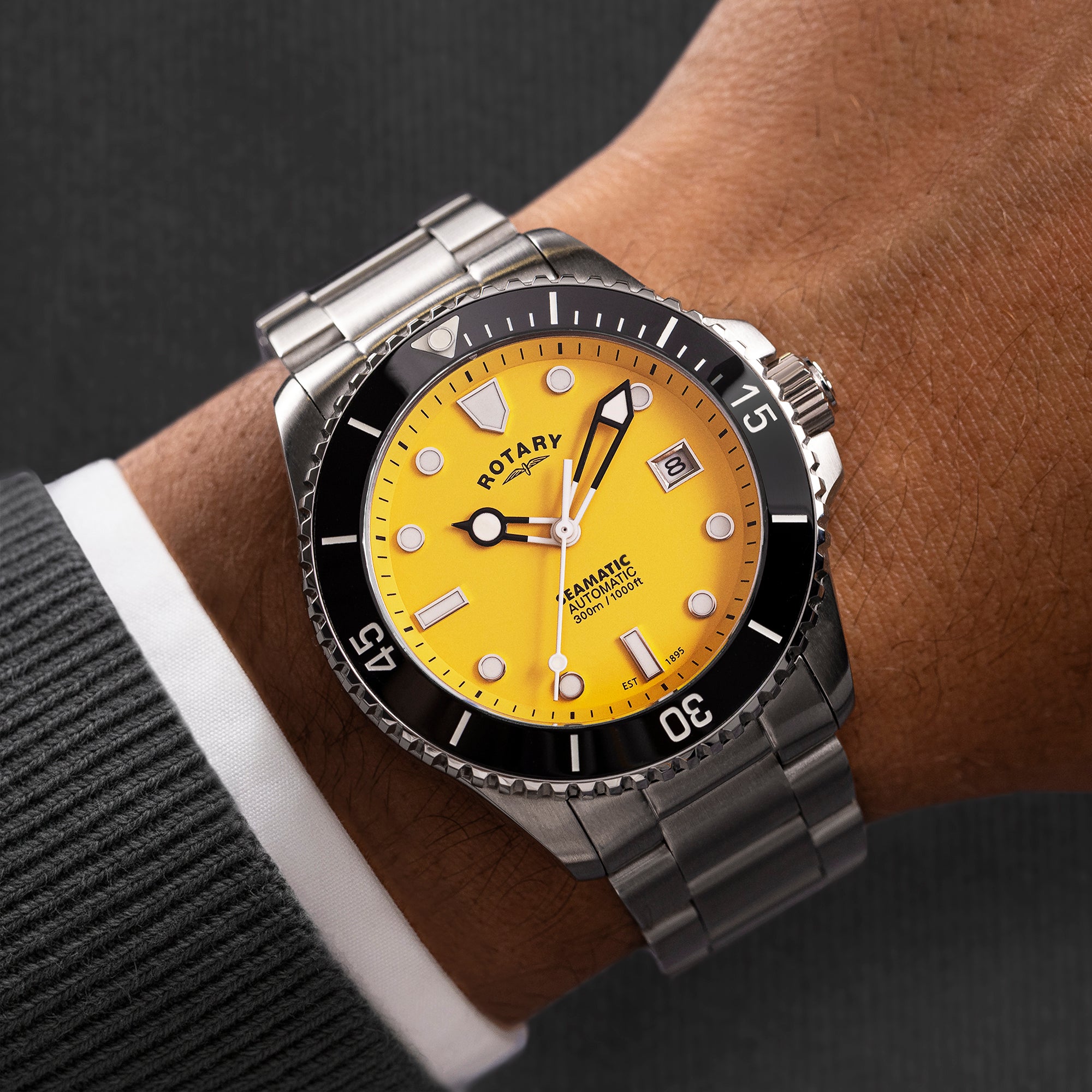 Rotary Seamatic watch with yellow face and silver metal strap on wrist