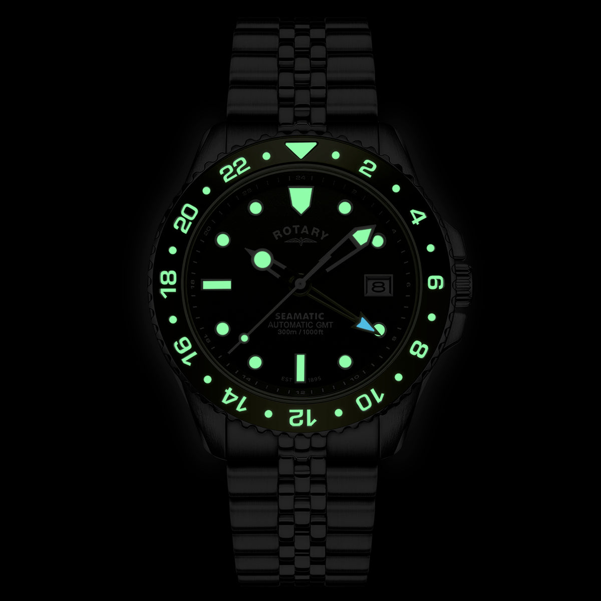 A Rotary Sematic 300 GMT wristwatch with a matching black link bracelet, featuring a black dial, luminous green hour markers and bezel numerals, and a date window at 3 o'clock, shown against a solid black background.
