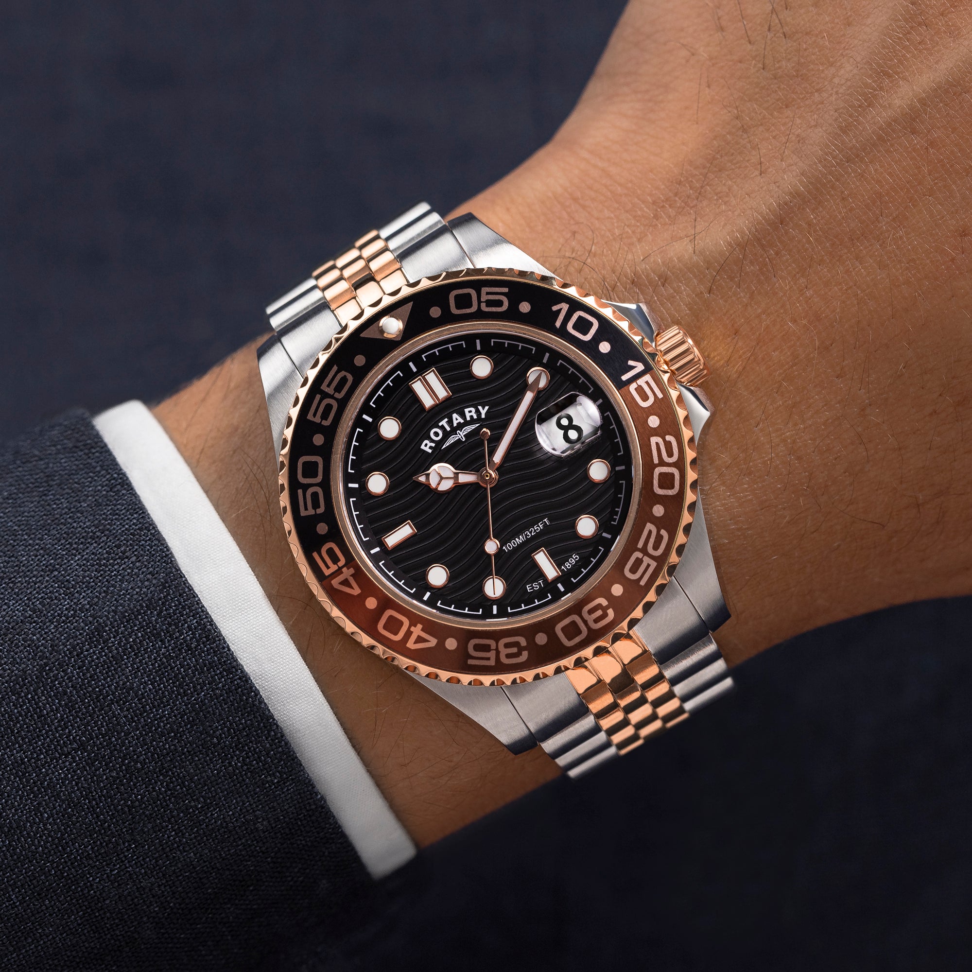 Luxury watch with black dial and rose gold accents on a wrist.