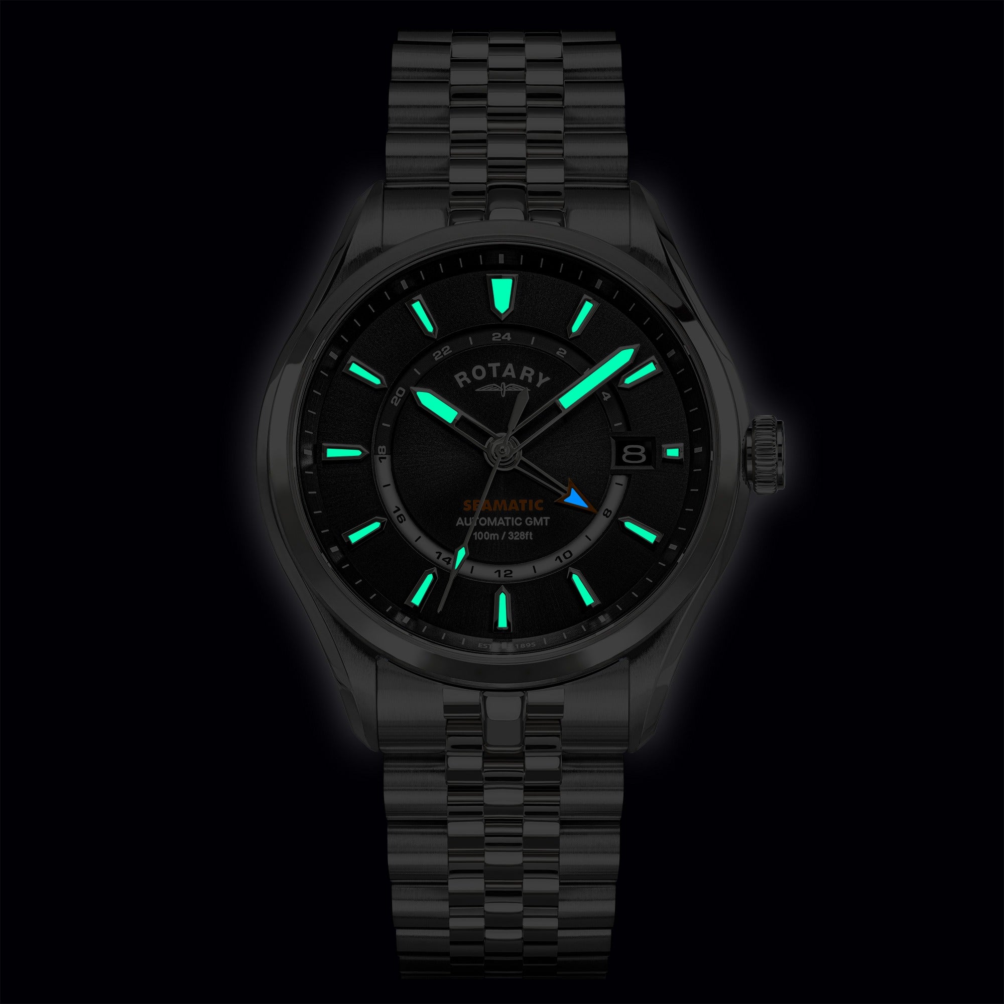 Silver Rotary Seamatic 100 GMT watch with green glowing hands on a black background
