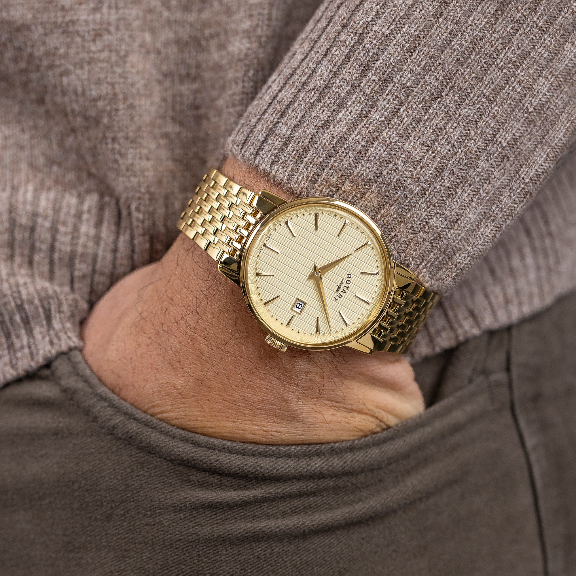 Gold Rotary 1895 watch on a wrist with a neutral background