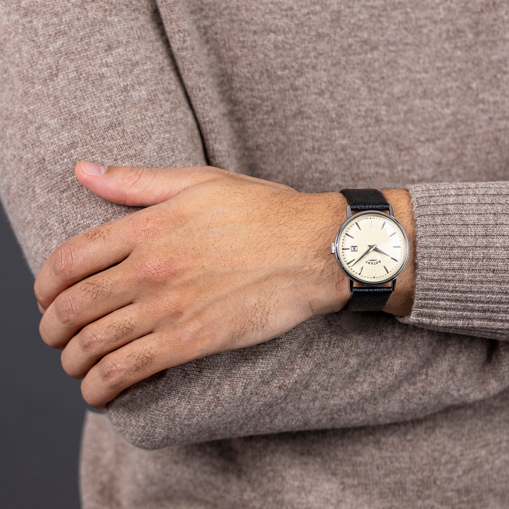 Person wearing a Rotary 1895 watch with a neutral background