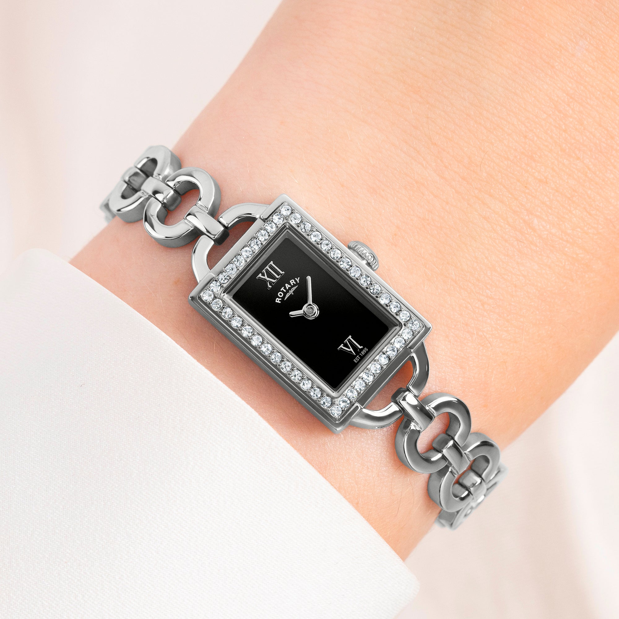 Silver Rotary 1895 bracelet with a black square watch face on a wrist against a light background