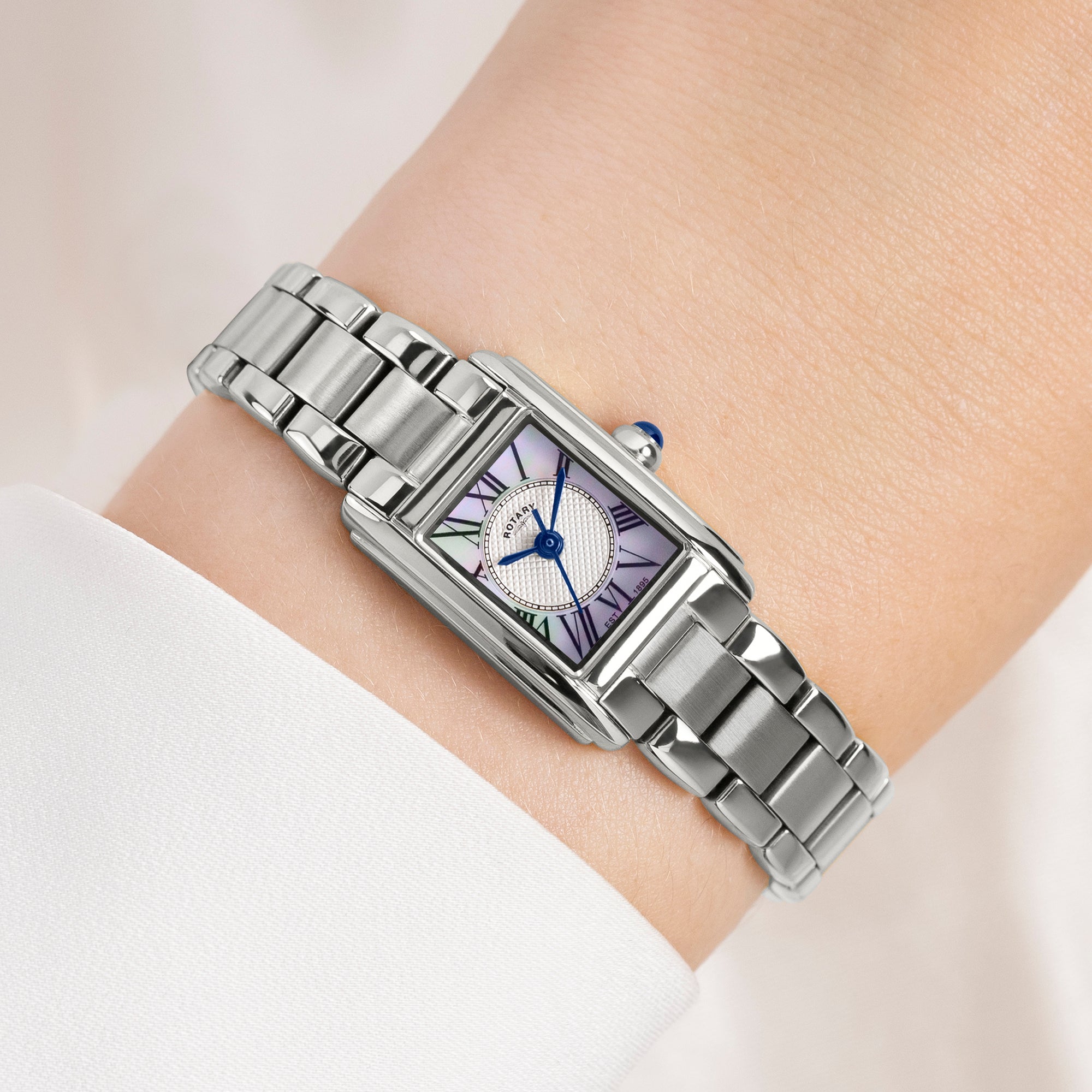 Silver Rotary watch on a wrist with a white background