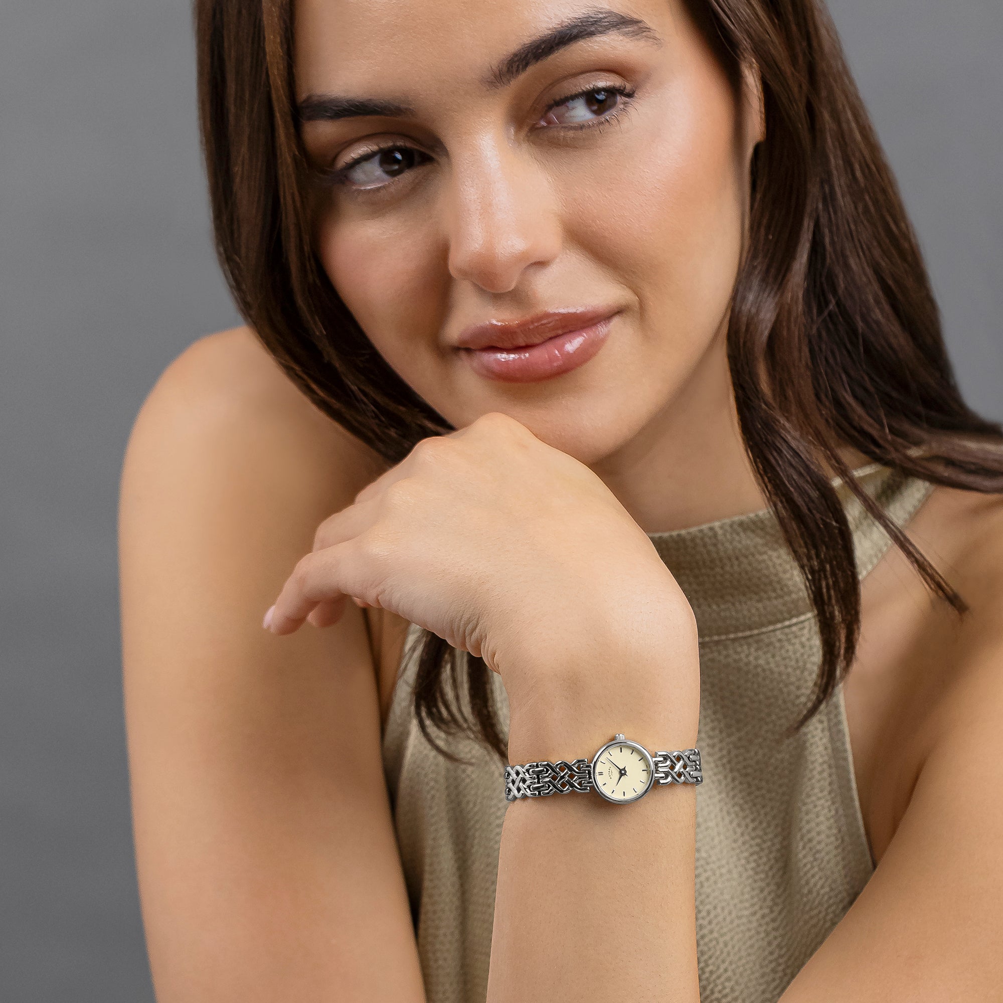 Woman wearing a Rotary 1895 watch on her wrist with a neutral background