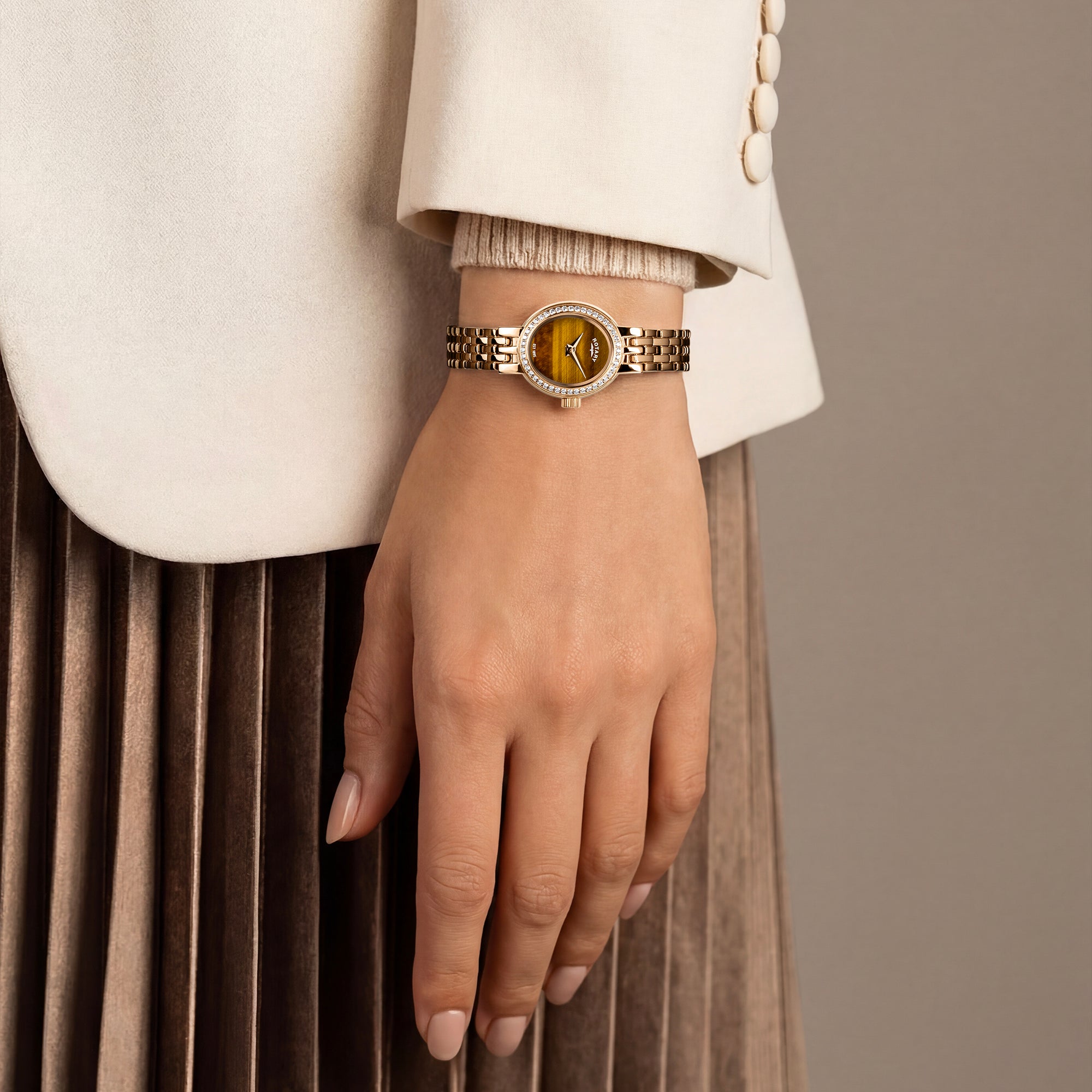 Gold Rotary cocktail watch on a ladies wrist with a neutral background