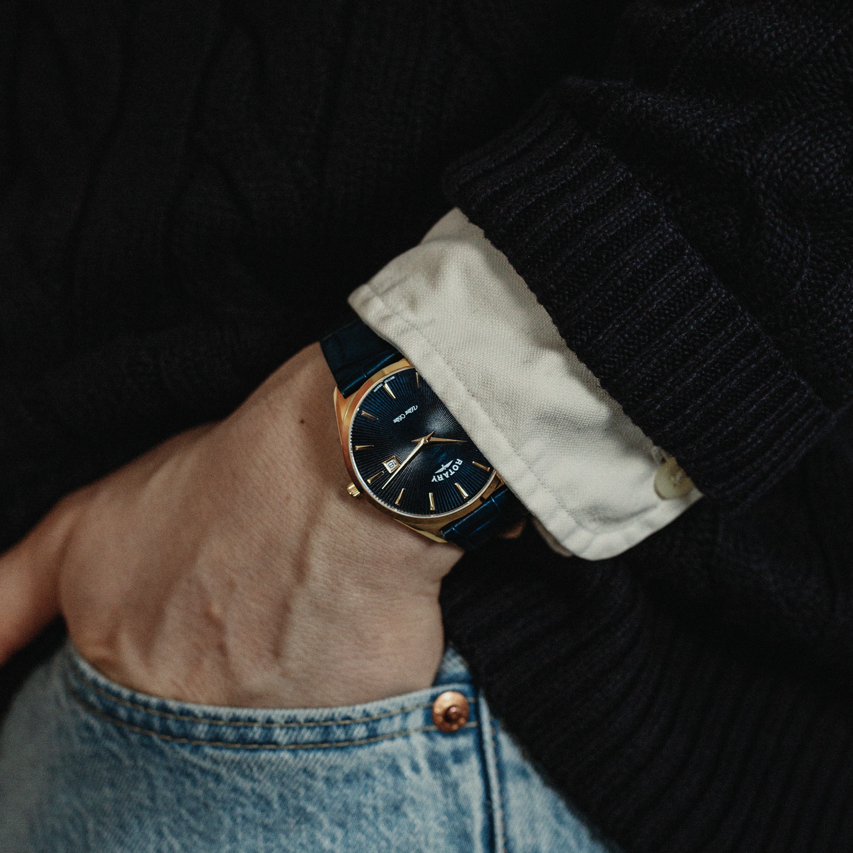 A man wearing a shirt with a Rotary Ultra Slim watch in blue and gold on his wrist