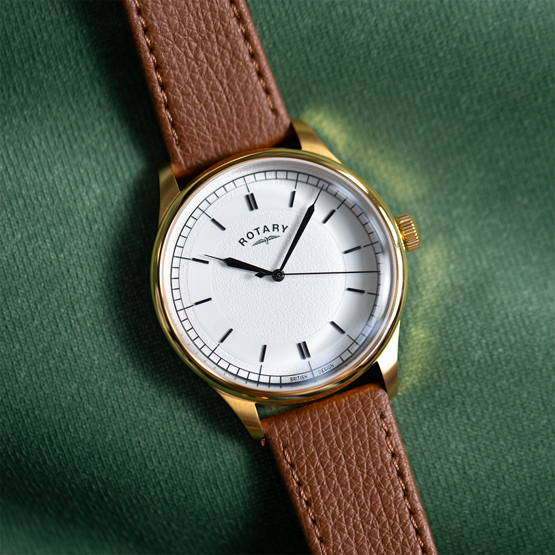 Rotary traditional watch with a gold case, a white textured dial and a brown leather strap