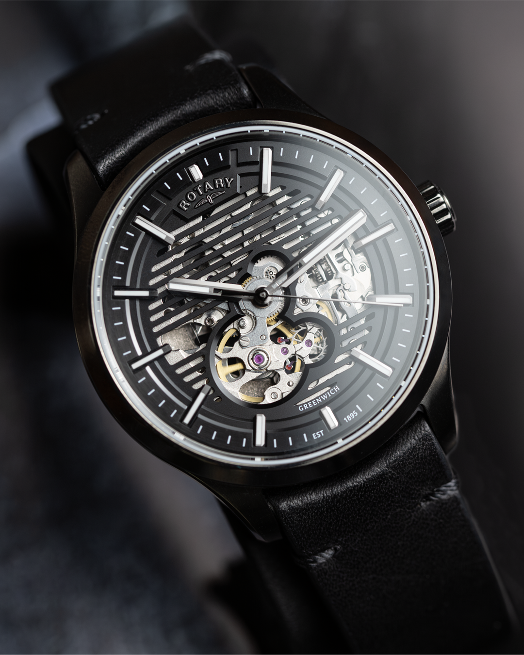 Black Rotary Greenwich GT1 wristwatch with visible mechanical components on a dark background