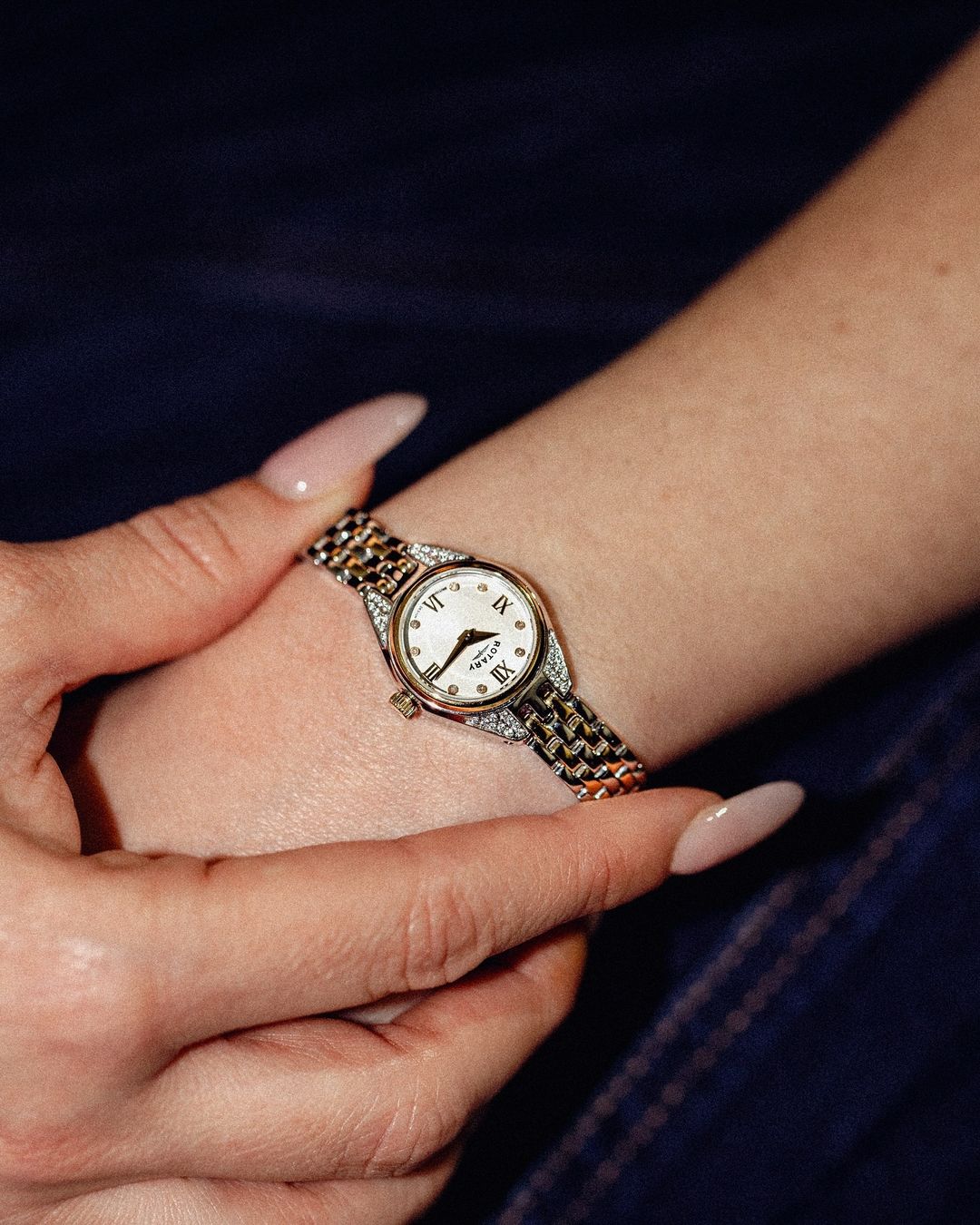 Rotary small ladies watch with crystal and diamond set case and dial. The watch is being worn by a woman with black clothing