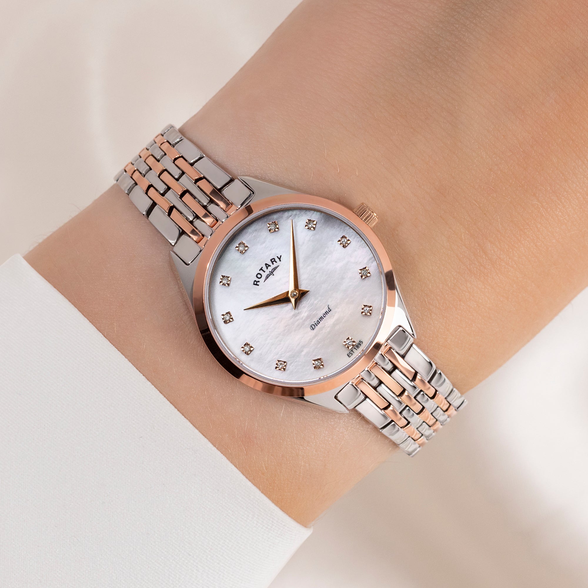 Two-tone Rotary watch on a wrist with a neutral background