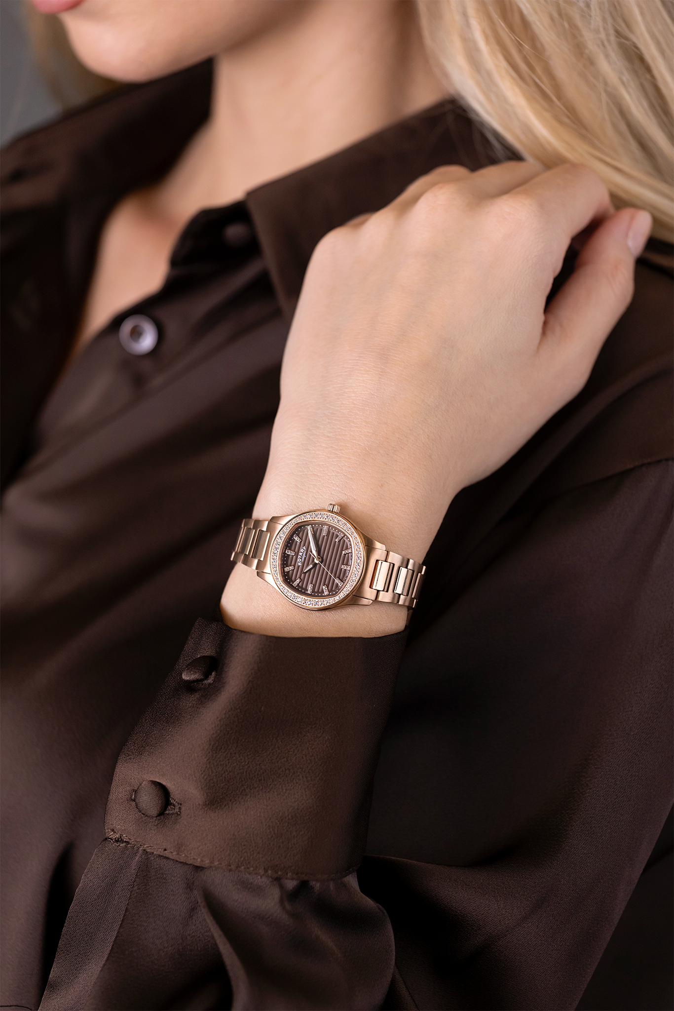 Woman wearing a Rotary Brilliance rose gold watch on a brown shirt