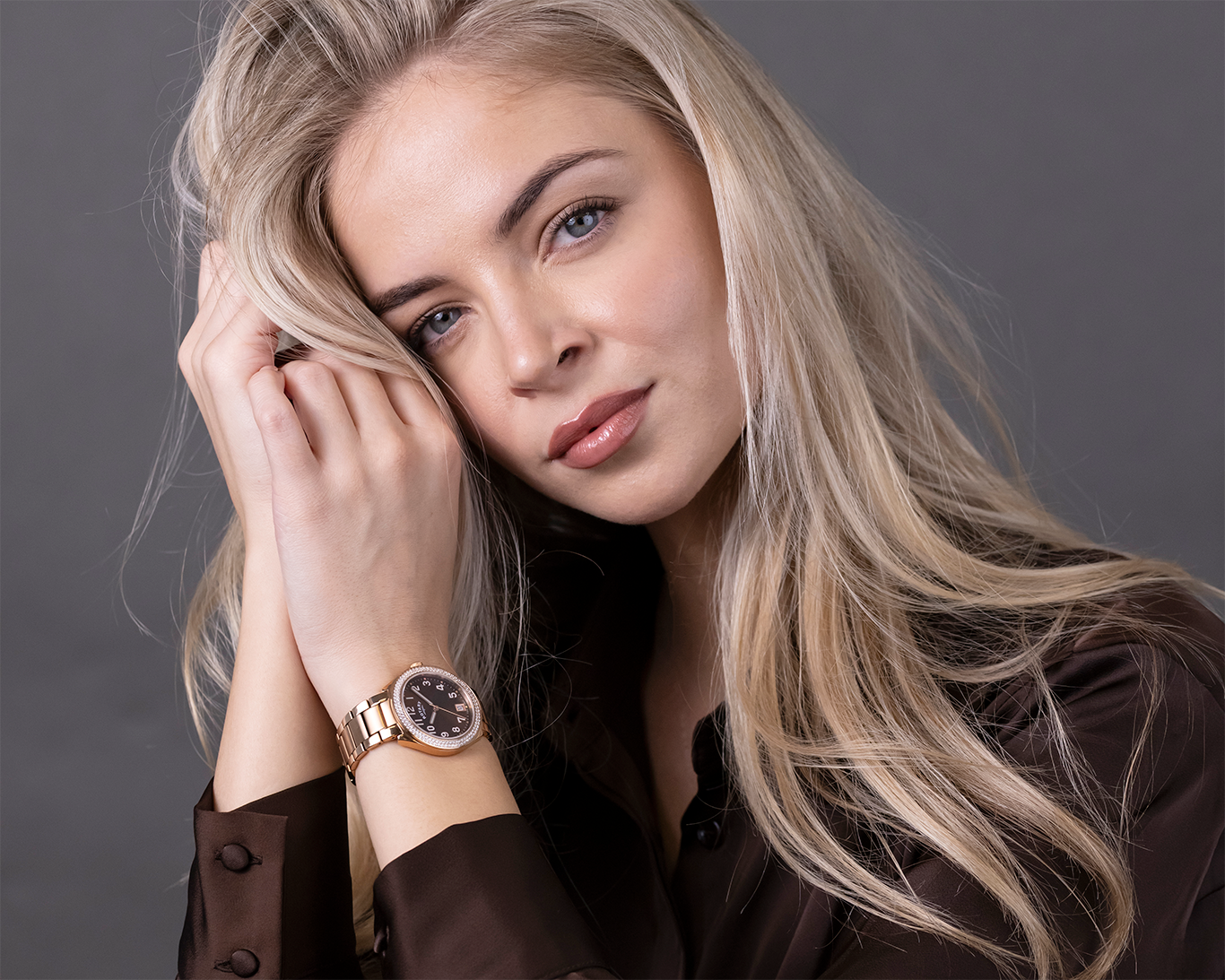 Woman wearing a Rotary Brilliance watch with a brown background