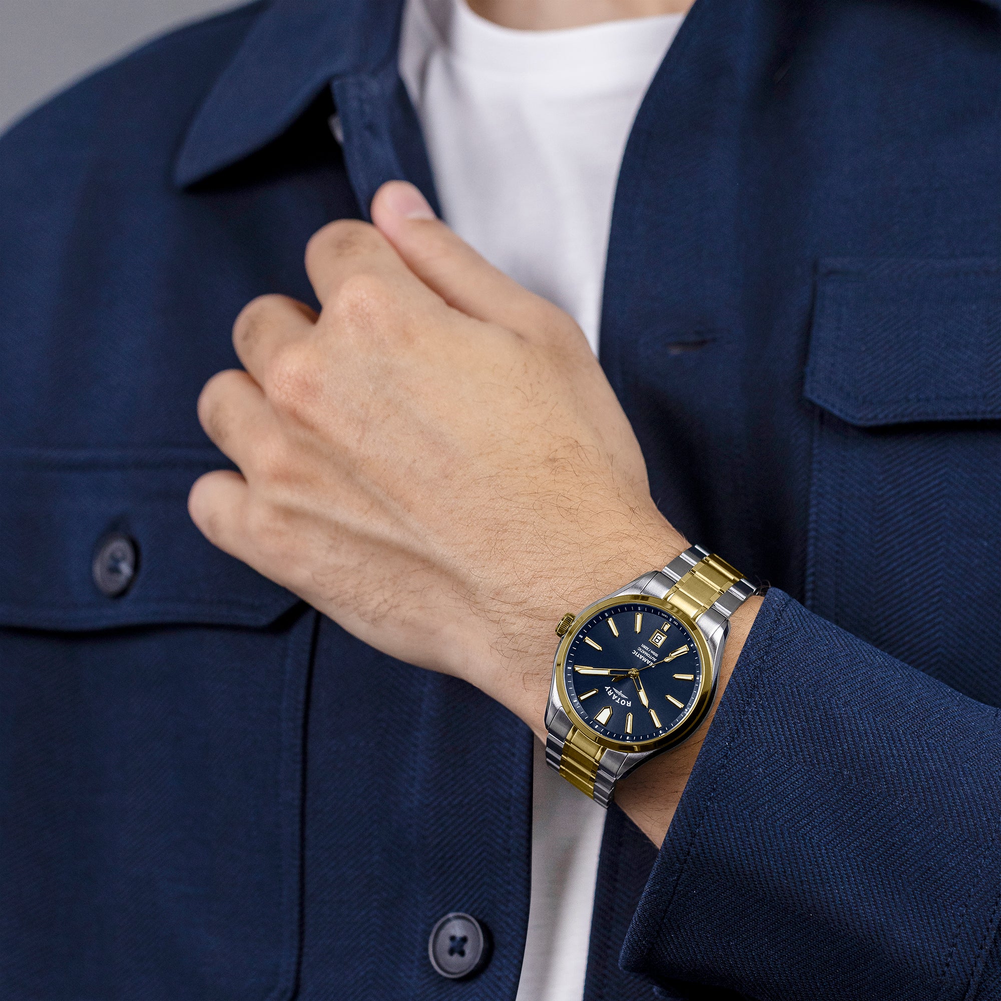 Rotary Seamatic 100 watch in two-tone with a blue dial being worn by a man in a blue coat