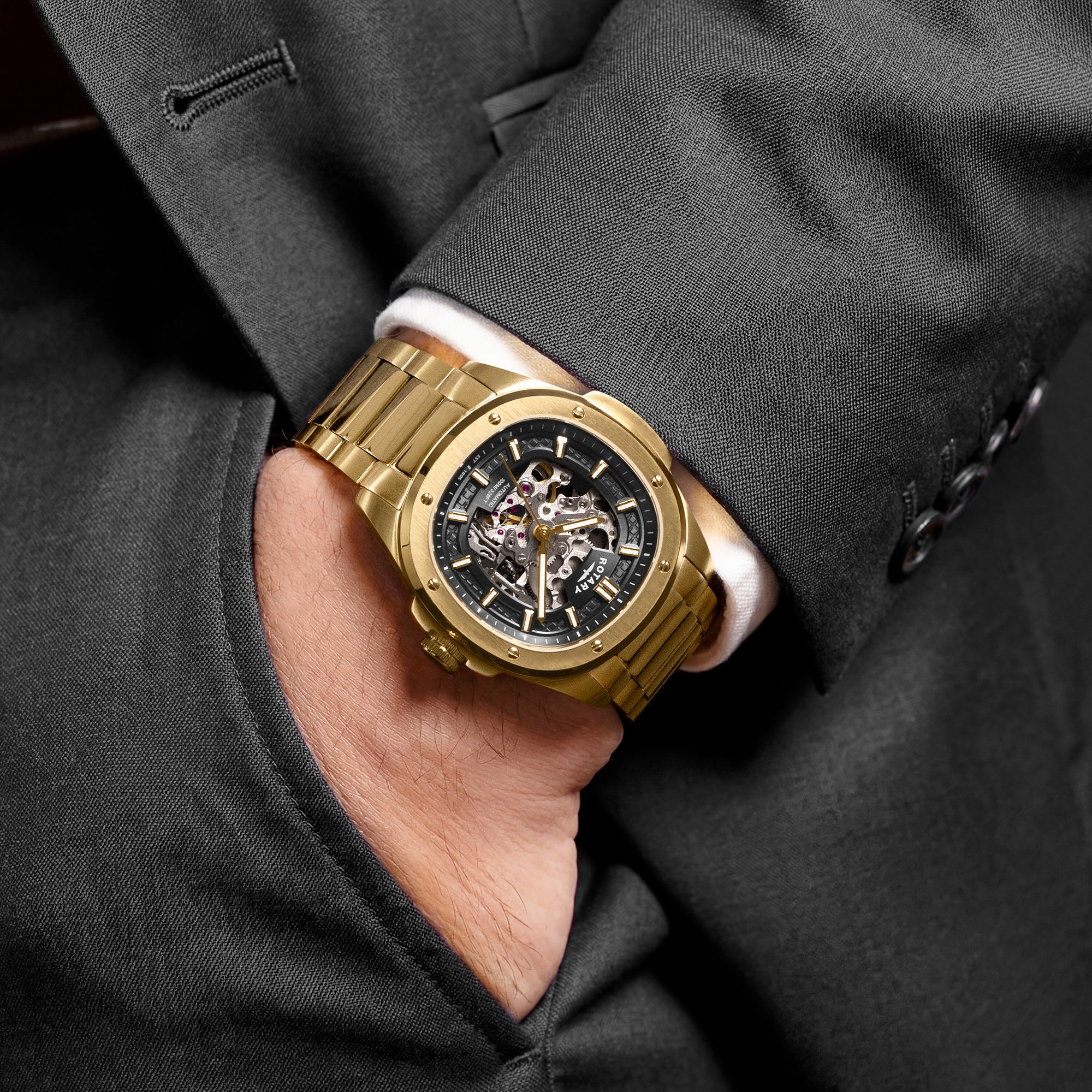 Gold Rotary Apex100 automatic wristwatch on a man wearing a dark suit
