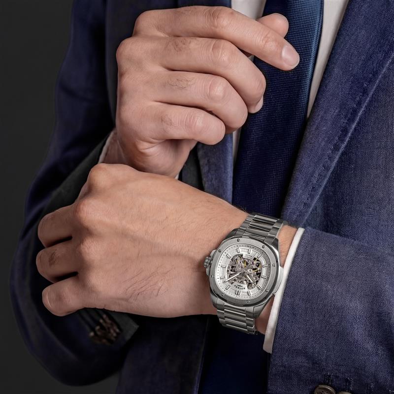 Person wearing a silver Rotary Apex100  Skeleton watch on a dark background