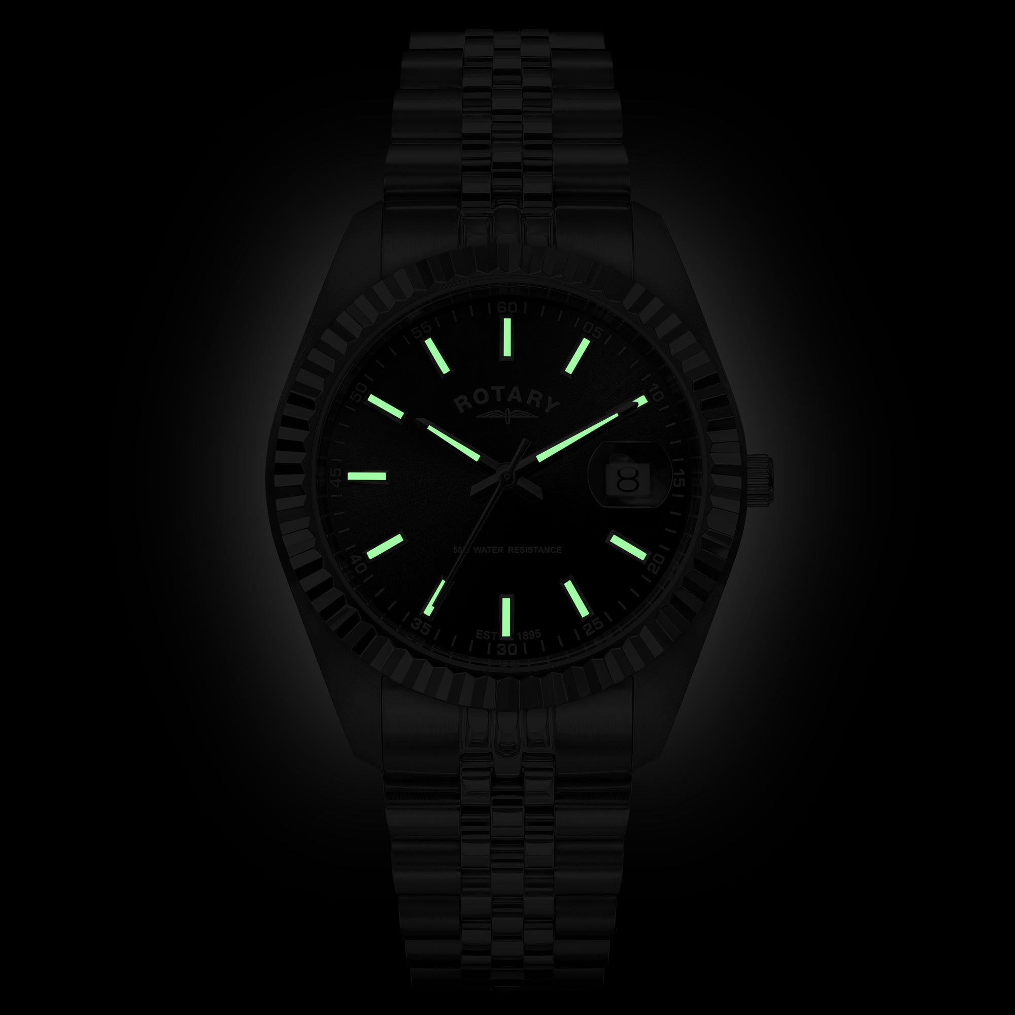 A stainless steel Rotary wristwatch with a matching bracelet, featuring glowing green luminous hour markers and hands on a dark black dial. The brand name 'ROTARY' is visible on the dial.