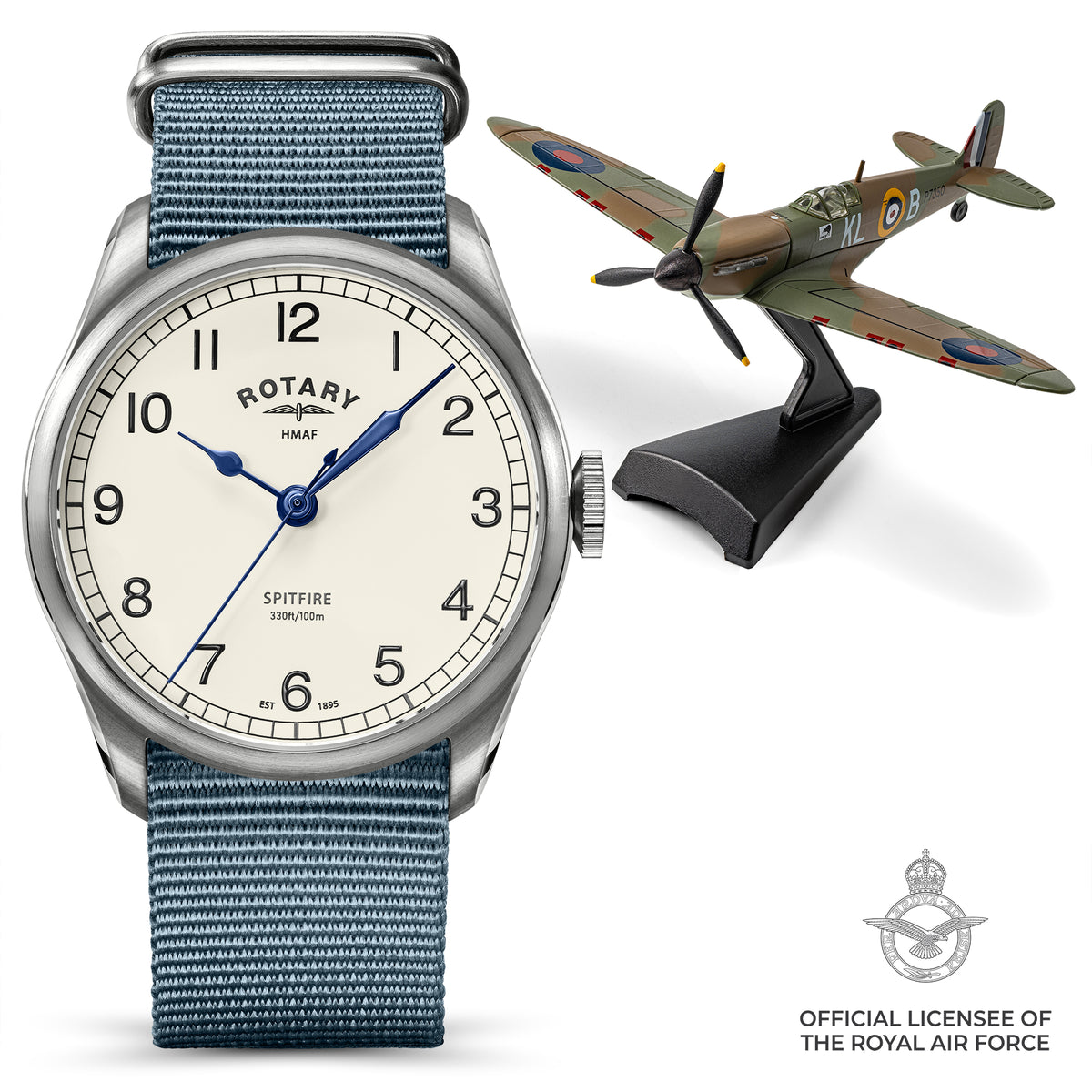 A Rotary x MoD HMAF Spitfire wristwatch with a blue textured fabric strap and an off-white dial, shown alongside a model Spitfire airplane on a display stand. The image includes an official licensee logo for the Royal Air Force in the bottom right corner.
