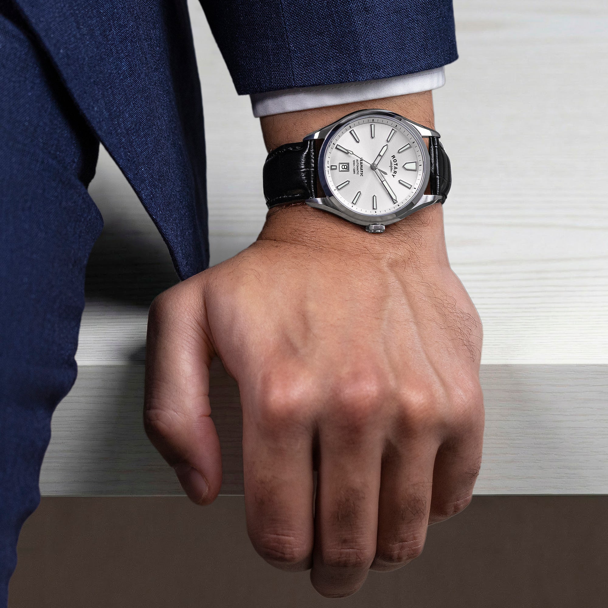 Man wearing a Rotary Seamatic 100 watch with a blurred background