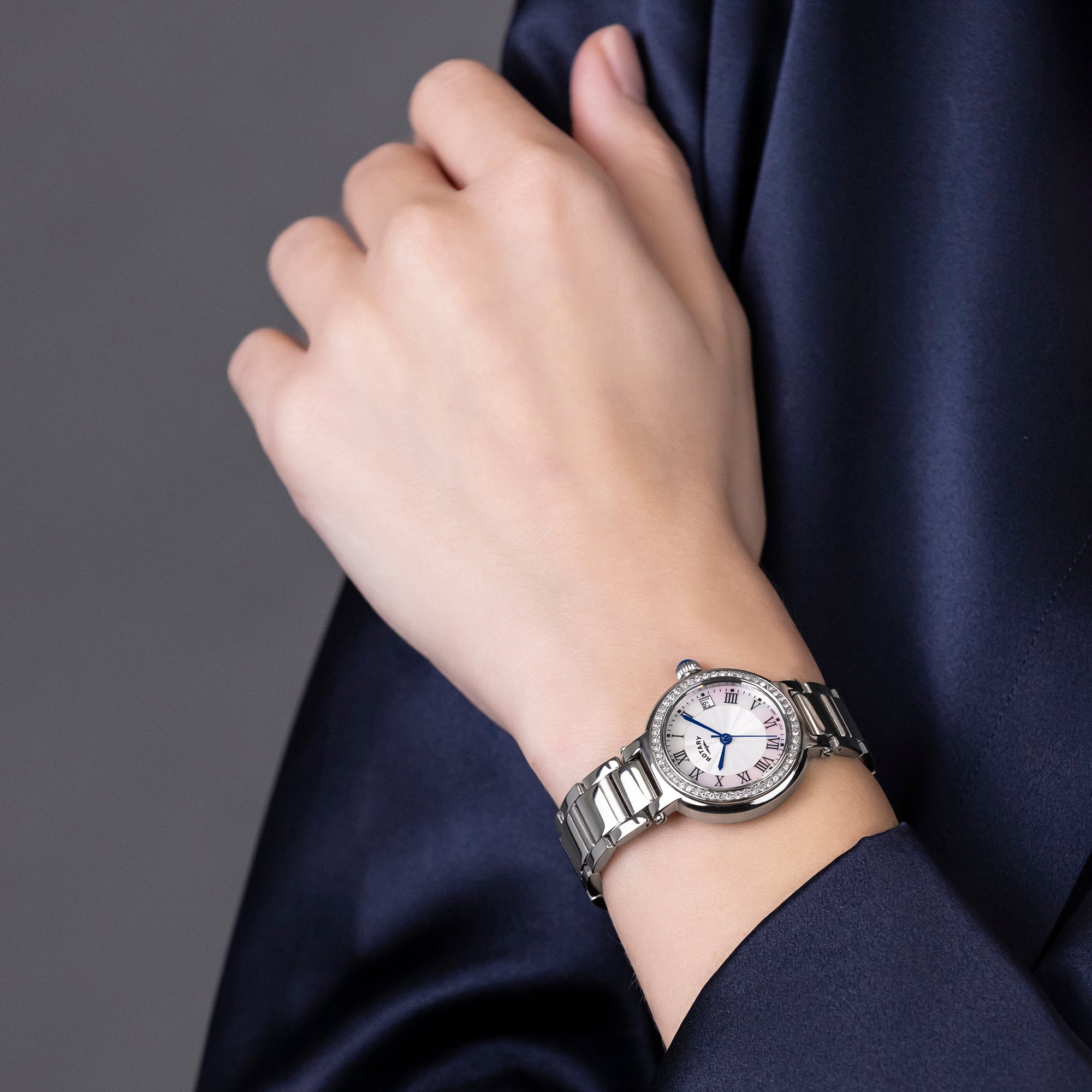 Silver Rotary wristwatch on a woman's wrist with a dark background