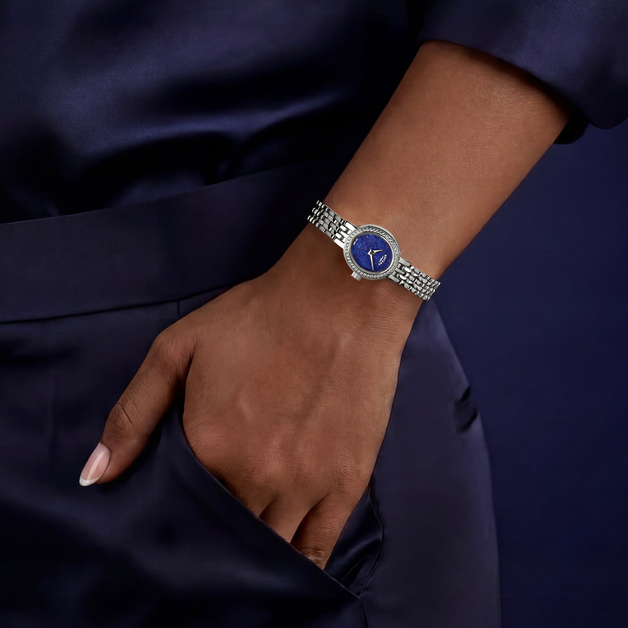 Silver ladies Rotary Cocktail watch with a blue face on a wrist against a dark background