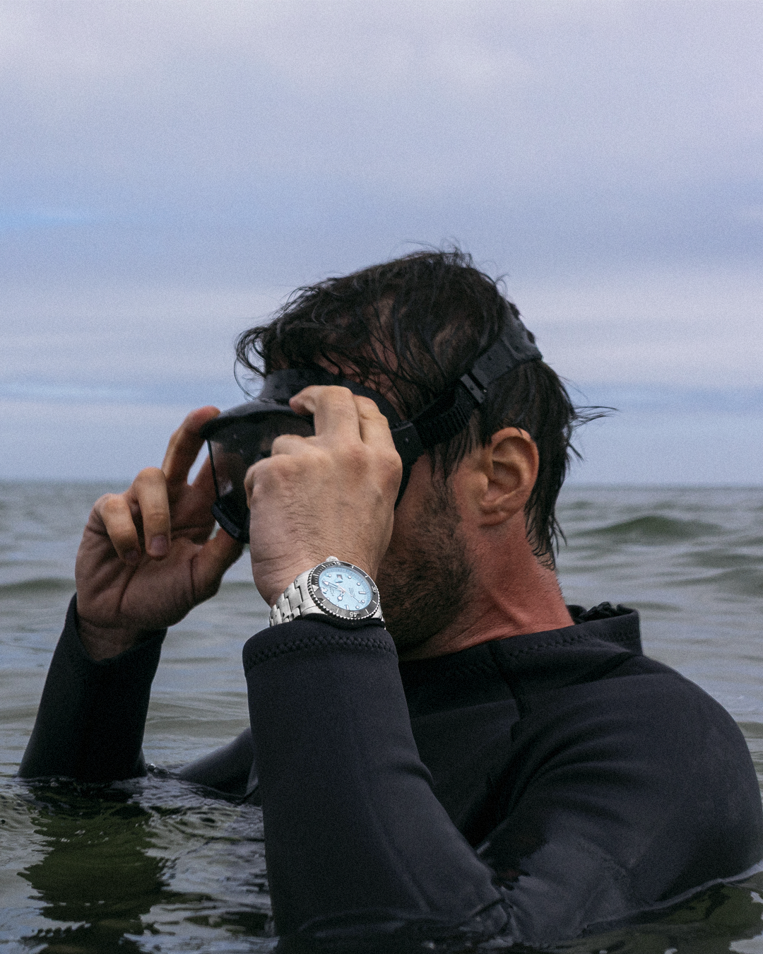 Person in wetsuit wearing a Rotary Seamatic watch whilst in the sea