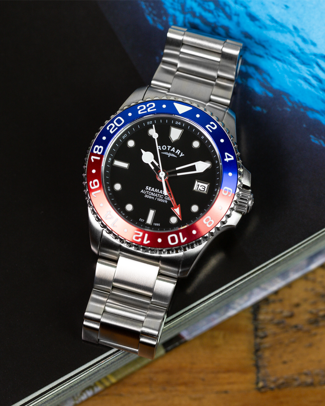 Rotary Seamatic GMT watch with a silver bracelet on a dark surface