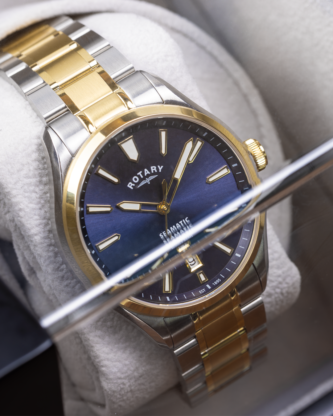 Rotary Seamatic 100 watch with gold and silver band on a white cushion