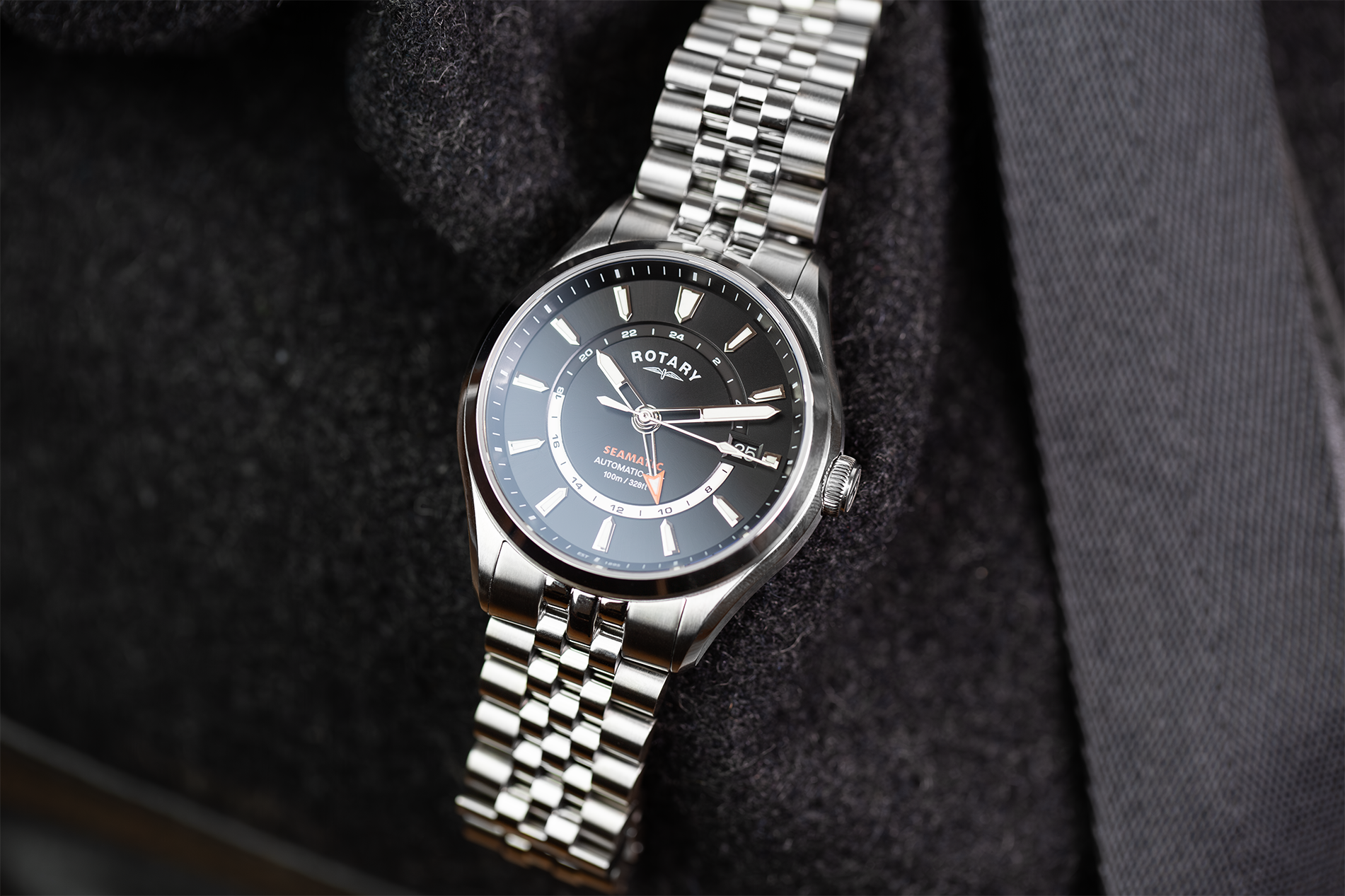 Silver rotary Seamatic 100 GMT watch on a dark textured background