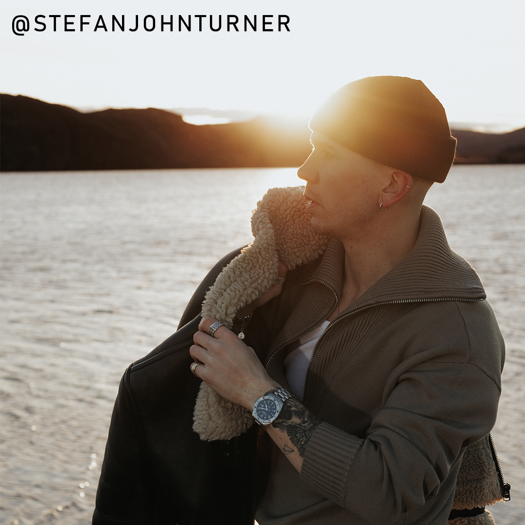 Stefan John Turner wearing a Rotary RW 1895 military styled watch with a sea scene in the background